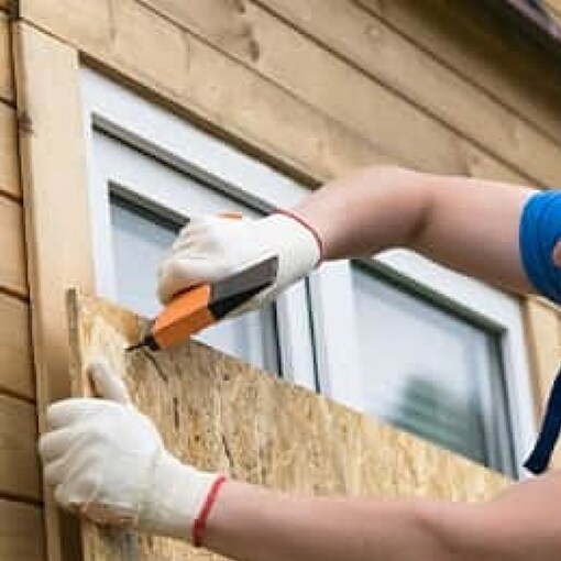 Homeowner boarding windows in preparation for a hurricane