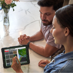 Homeowners designing their new roof with the GAF Virtual Home Remodeler on a tablet.
