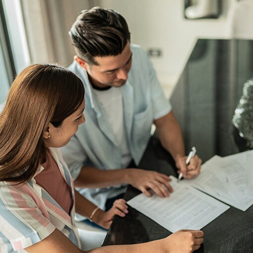 Man and women signing homeowner’s insurance paperwork after a storm
