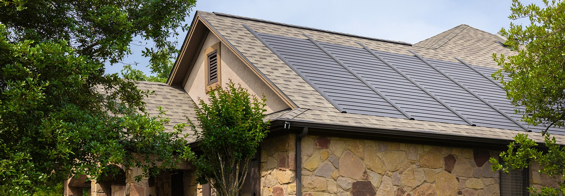 Side view of a roof featuring GAF Timberline asphalt shingles and Timberline Solar® ES 2 shingles, both installed as part of a complete GAF roofing system by a GAF-certified contractor.