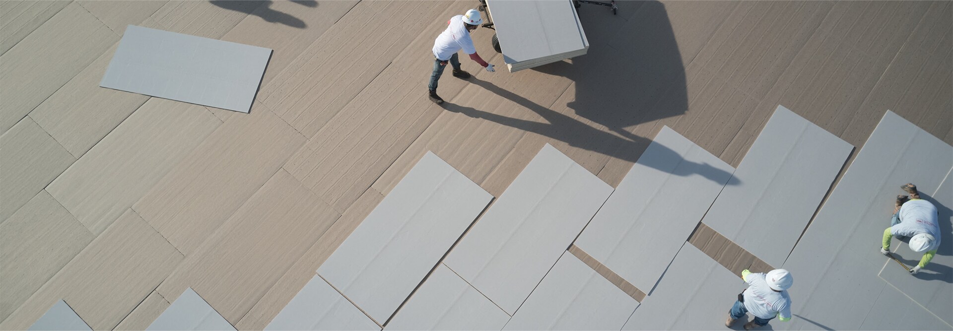 Commercial roofing contractors laying out EnergyGuard NH polyiso materials